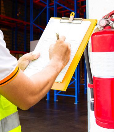 engineer-technician-checking-fire-extinguisher-writing-clipboard-warehouse_36860-744